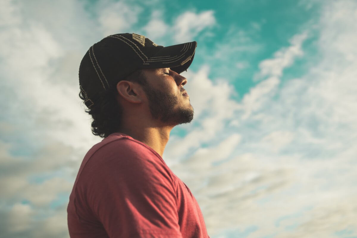 A Man With His Eyes Closed Is Taking In The Morning Sun