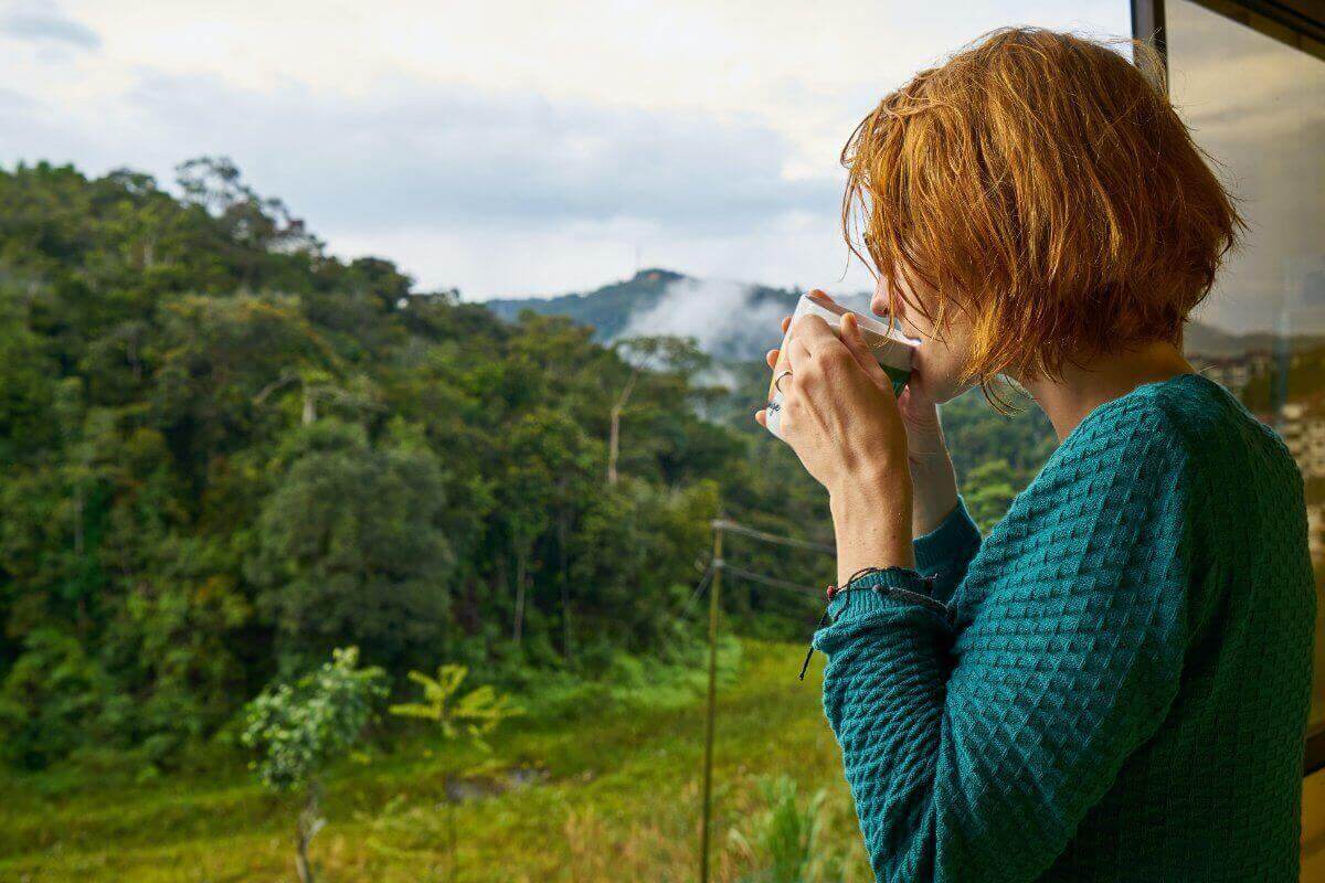 Woman Drinking Coffee While Watching Out Of The Window