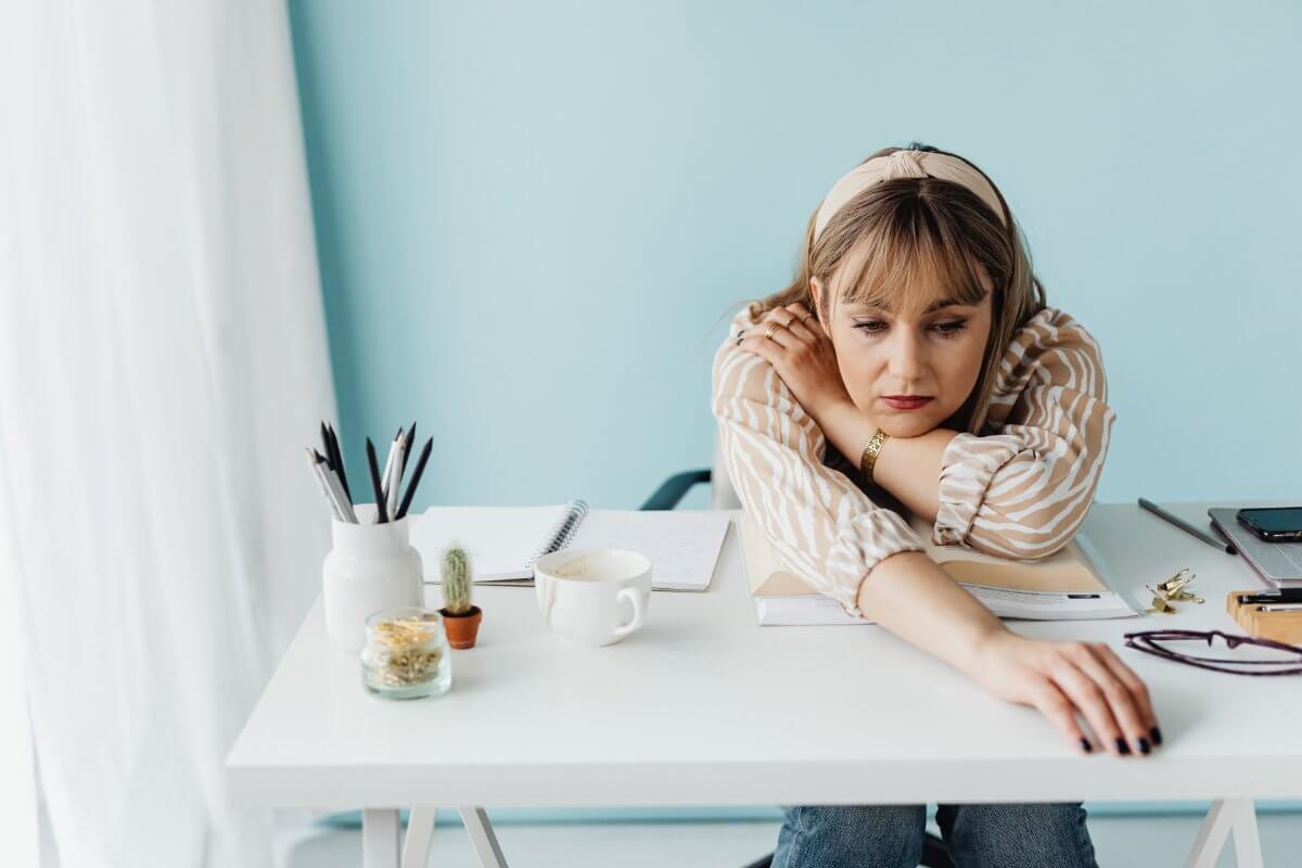 Woman Being Bored Slumped Over Their Desk