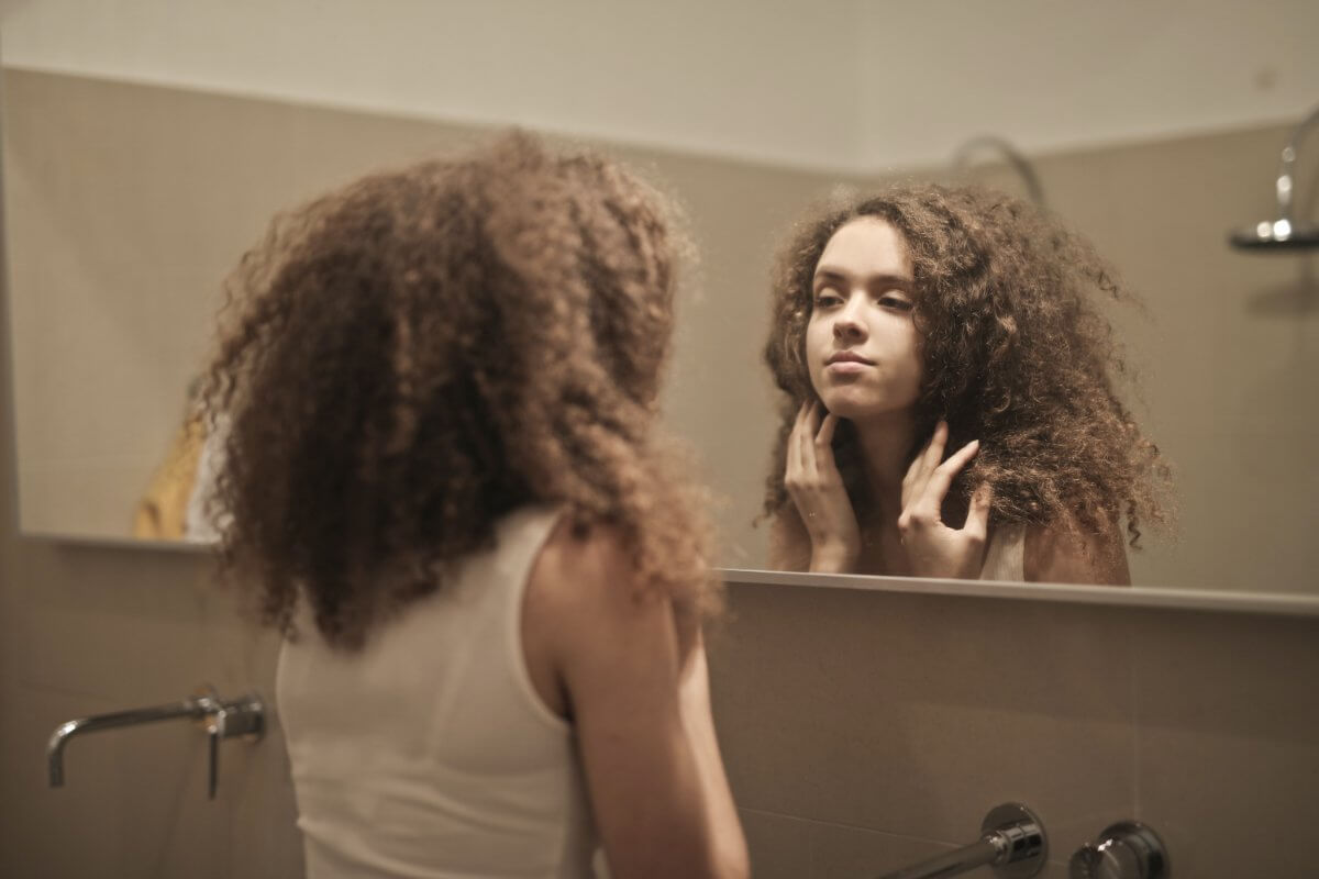 Woman Looking Into A Mirror