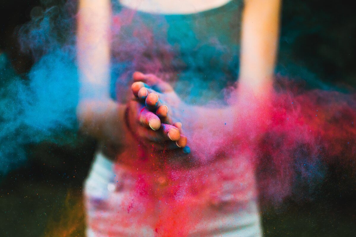 Woman Clapping Hands Over Colored Powder