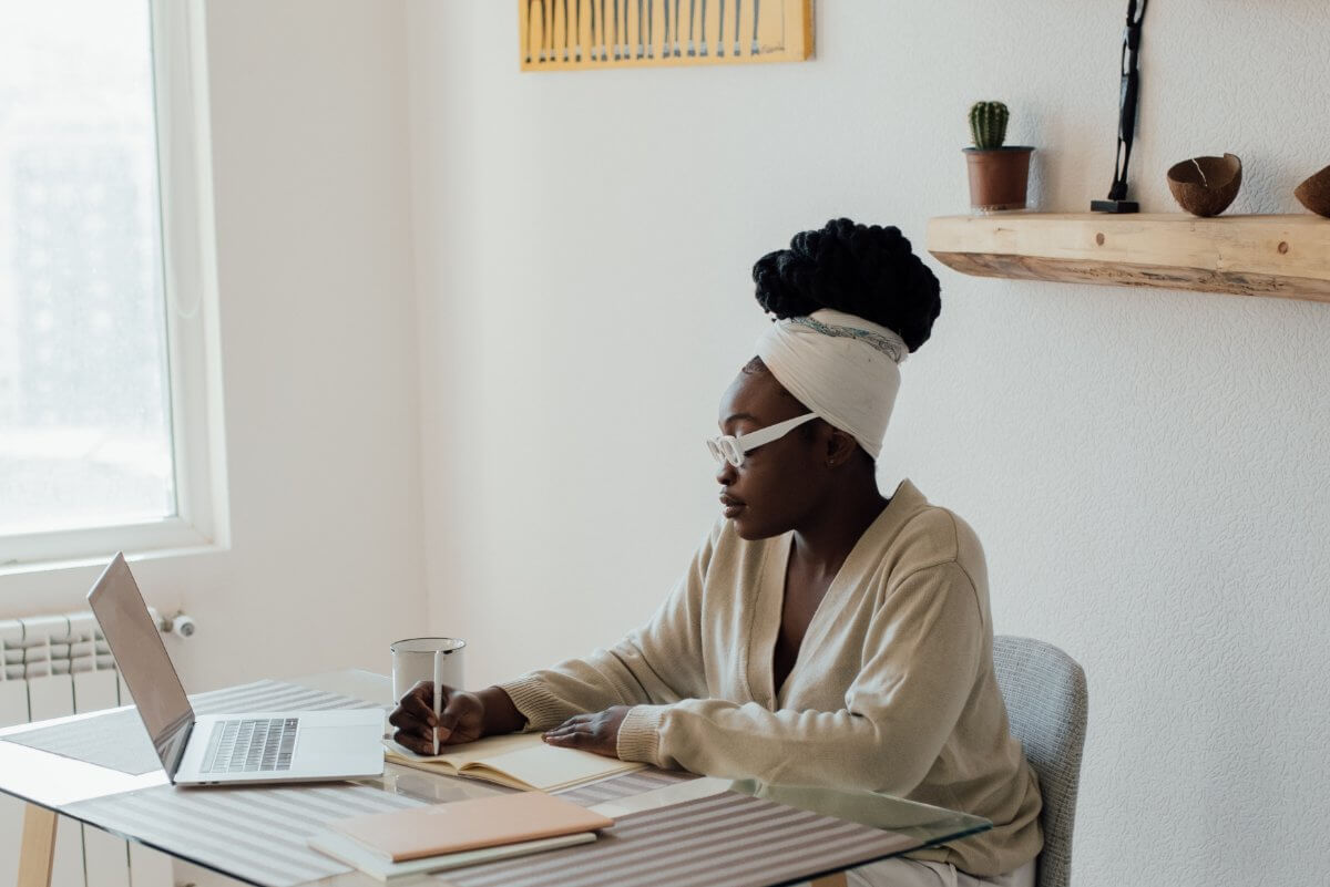 Woman Sitting Behind A Computer And Writing