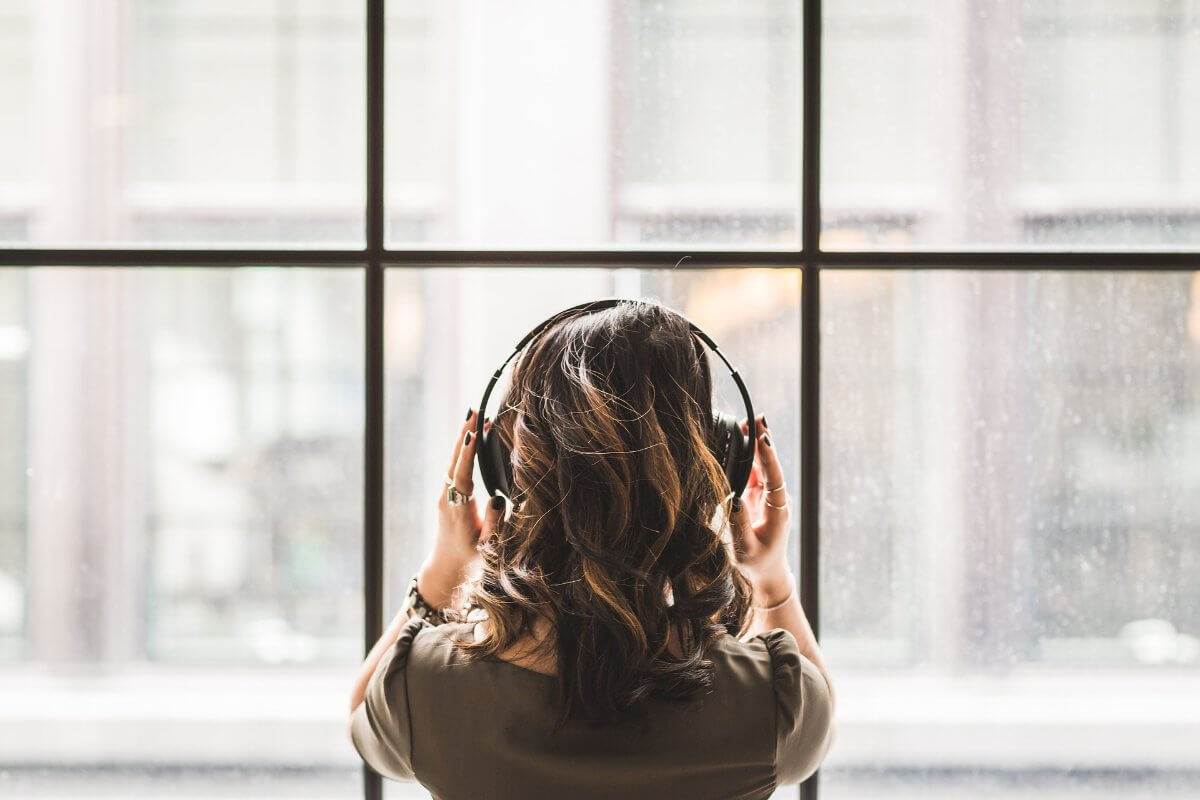 Woman Wearing Headphones Looking Out Of Window