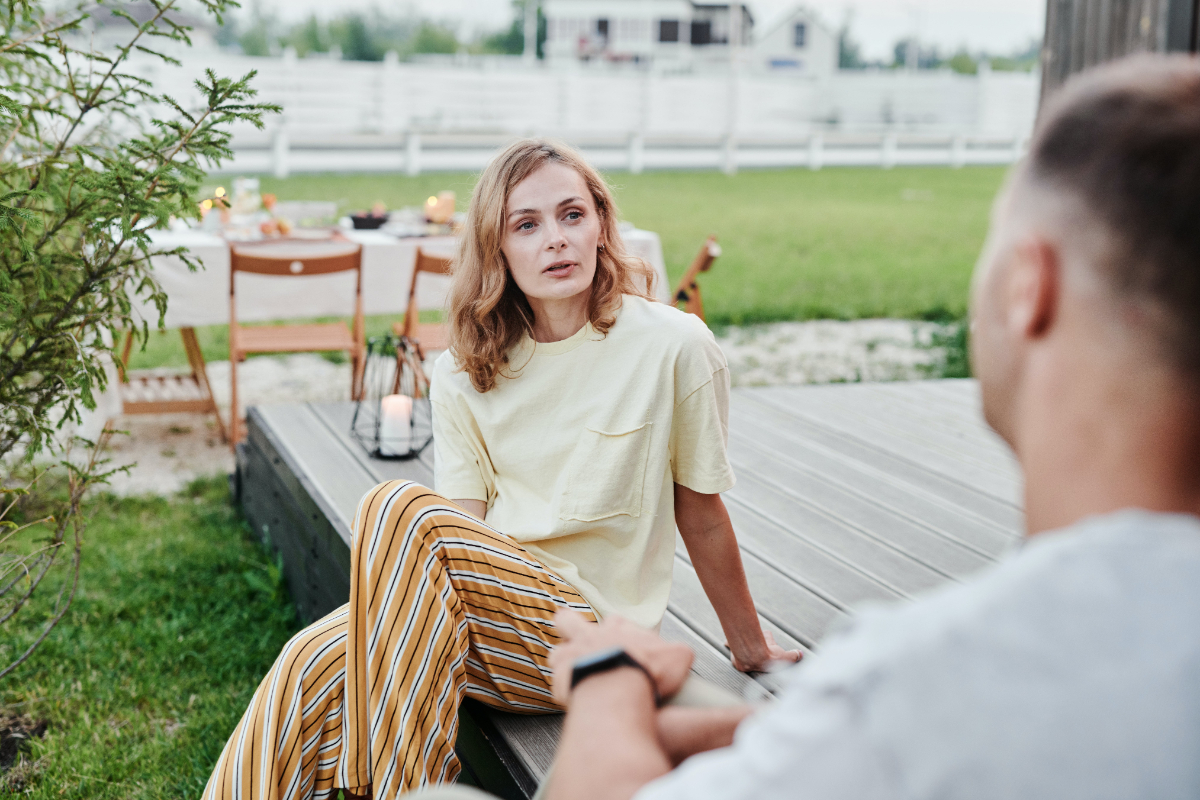 White Woman Sitting On A Wooden Terrace